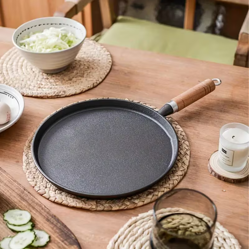 Fenn cast iron pan styled on a wood table with cabbage and cucumber