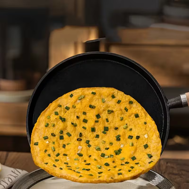 Fenn cast iron pan releasing a cooked pancake with scallions