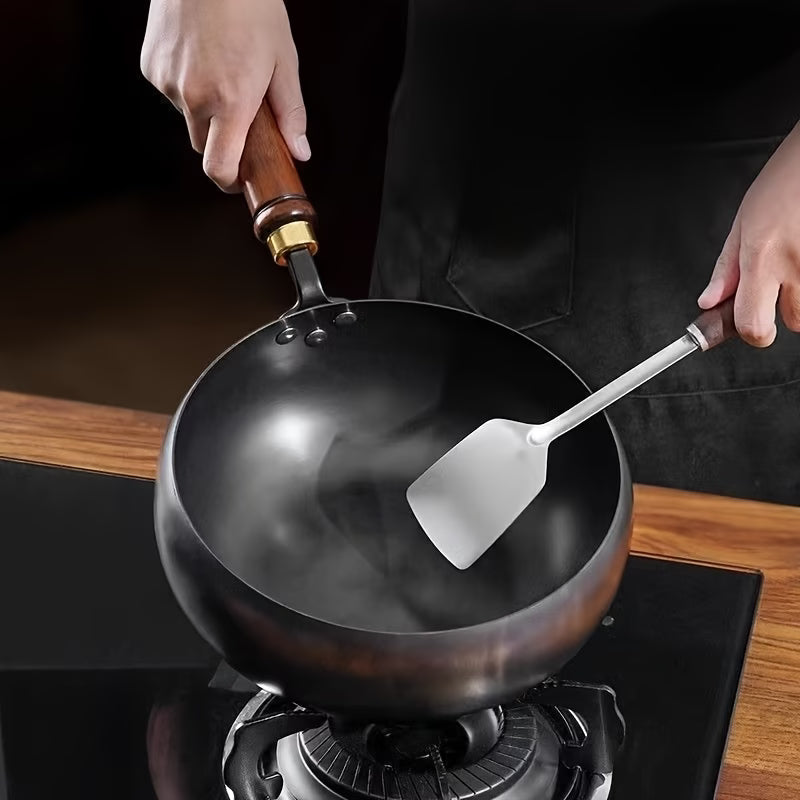 Fenn cast iron pot cooking on a gas stovetop with a spatula