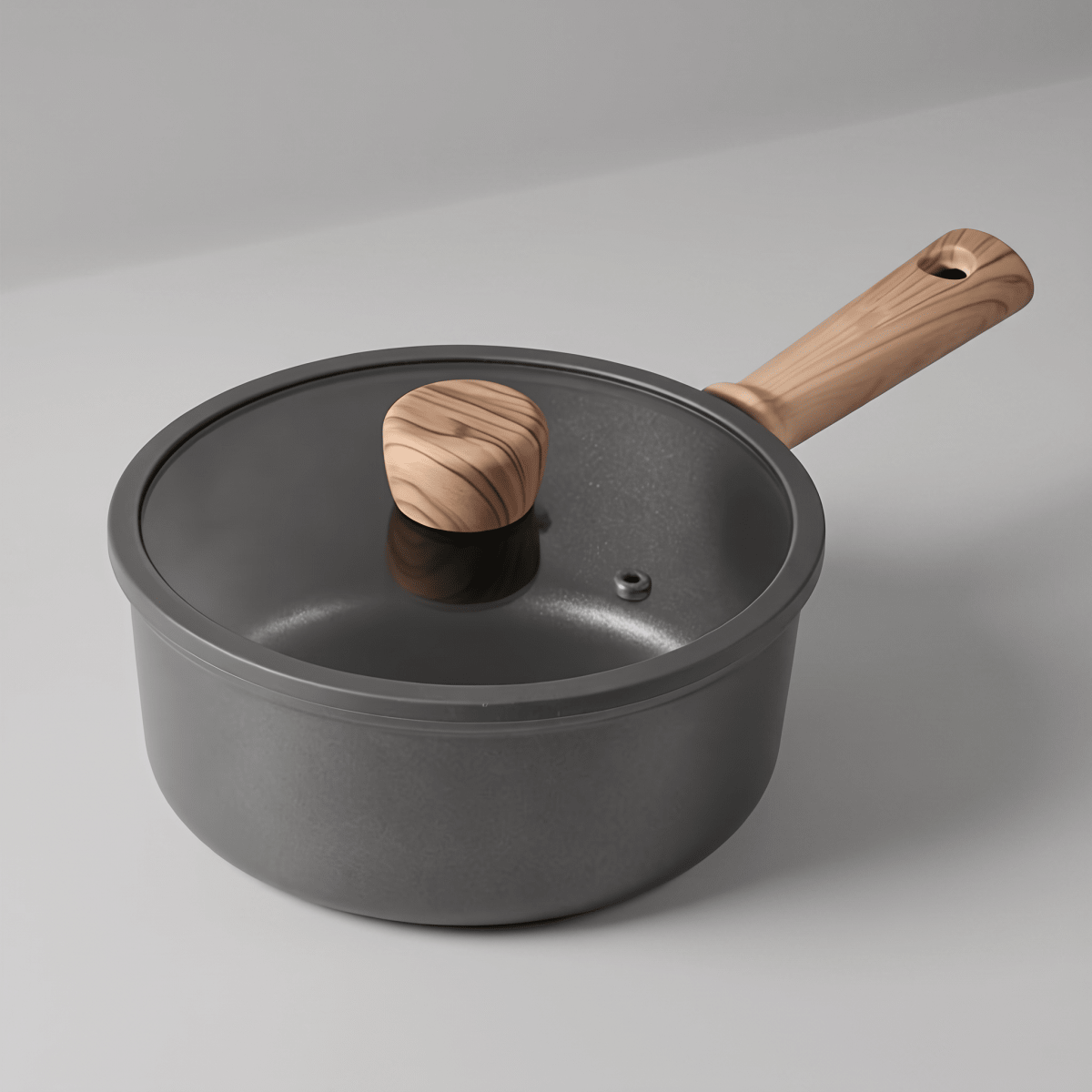 Fenn non-stick saucepan with glass lid and wood handle, angled view